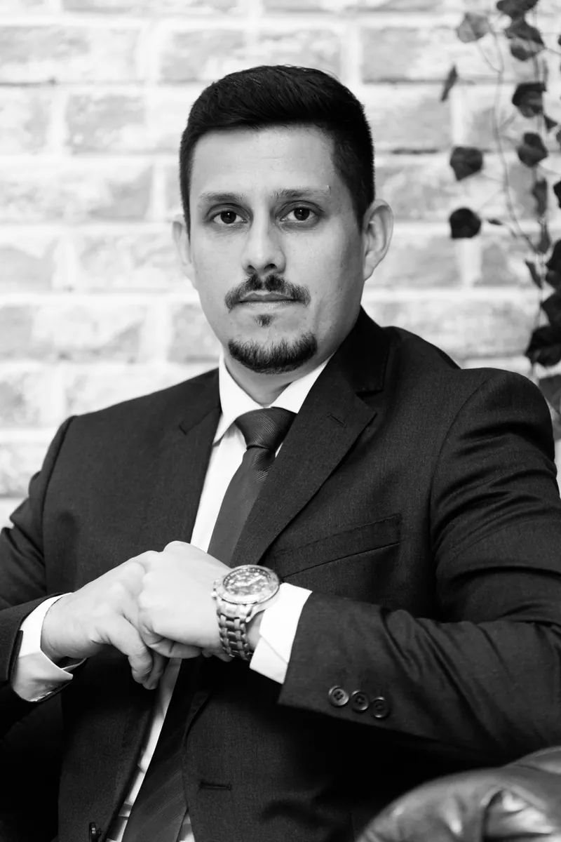 Retrato em preto e branco do Dr. Felipe Villela Gaspar ajustando o relógio